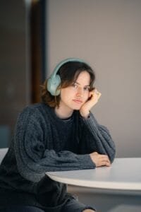 A woman sitting at a table with headphones on
