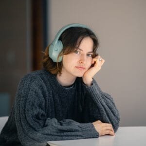 A woman sitting at a table with headphones on