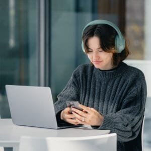 A woman sitting at a table using a laptop computer