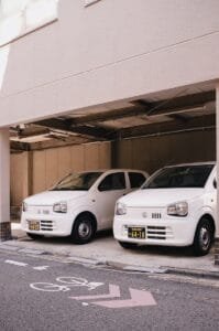 Two white cars parked in a parking garage