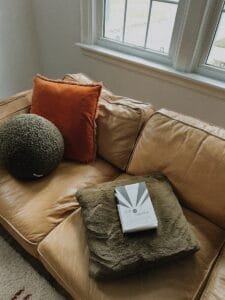 A couch with pillows and a book on it