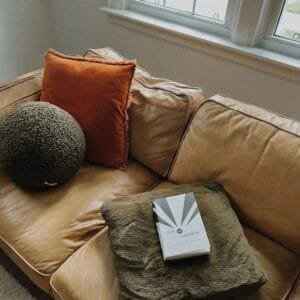 A couch with pillows and a book on it
