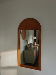 A mirror hanging on the side of a wall
