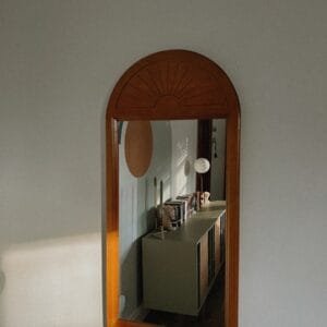 A mirror hanging on the side of a wall