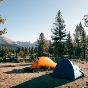 A couple of tents sitting on top of a dirt field