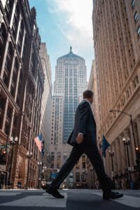 A man in a suit walking across a street