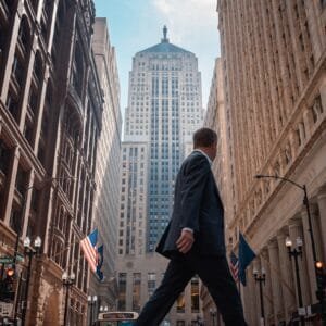 A man in a suit walking across a street