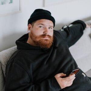 A man with a beard sitting on a couch